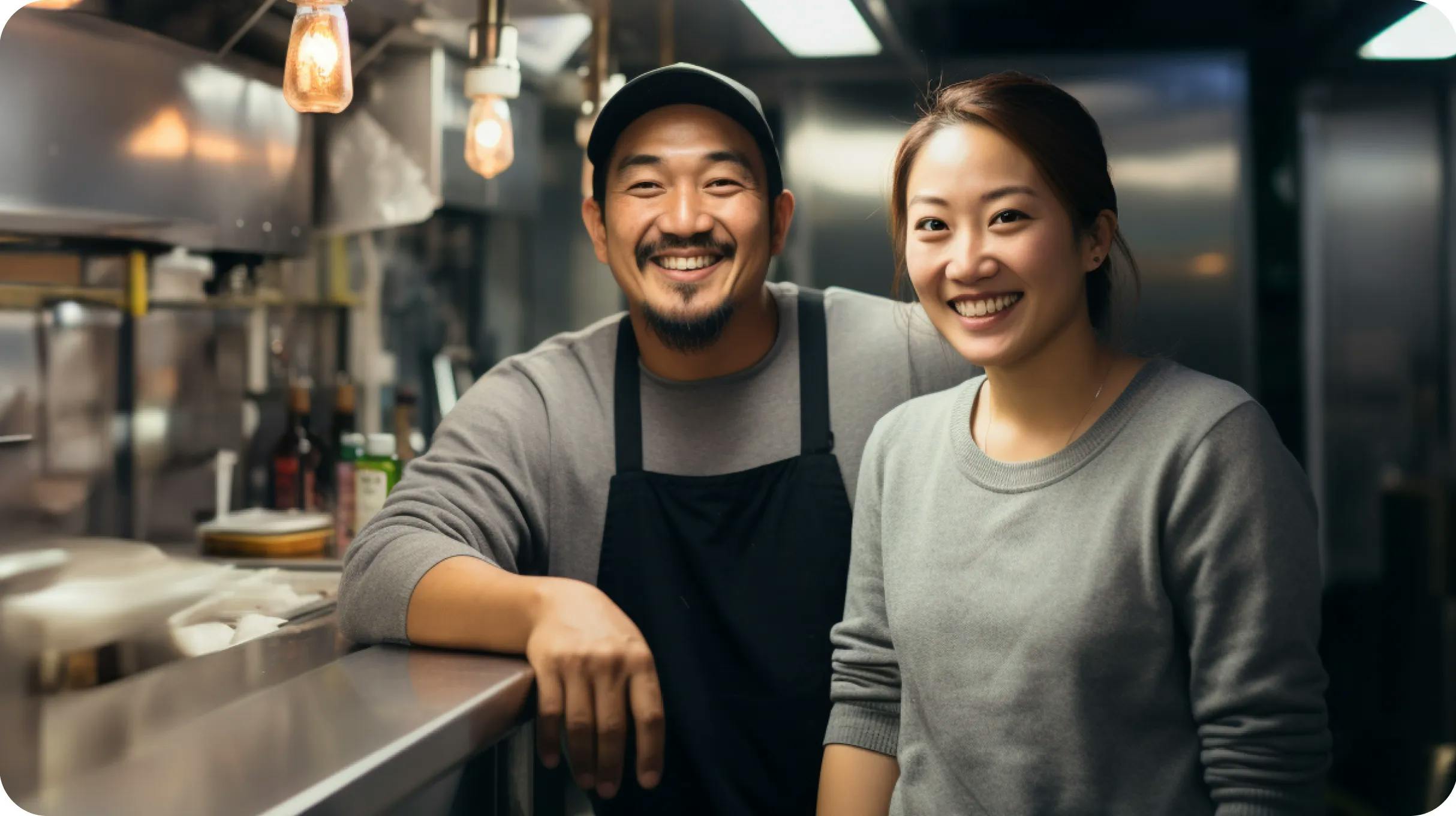 Asian couple standing in a commercial kitchen